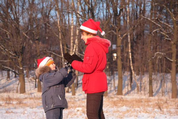 Mamma leker med sonen i trä på vintern — Stock fotografie