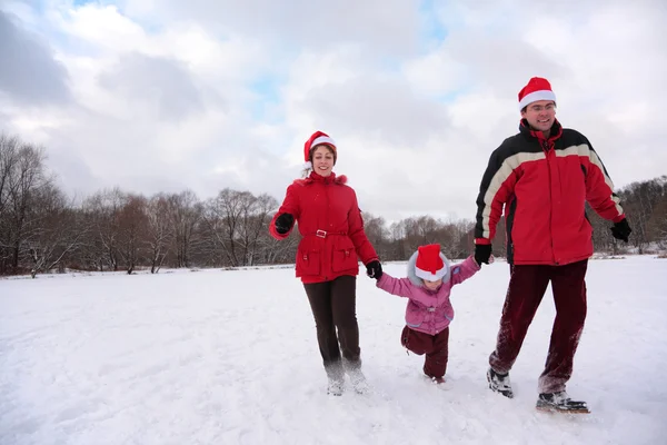 Pais com criança correm no parque no inverno — Fotografia de Stock