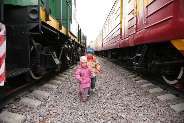 Twee kinderen tussen treinen — Stockfoto