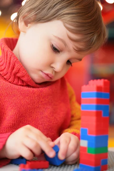 Klein meisje speelt met kunststof constructor — Stockfoto