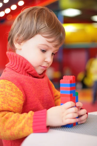 Klein meisje speelt met kunststof constructor in de kleuterschool — Stockfoto