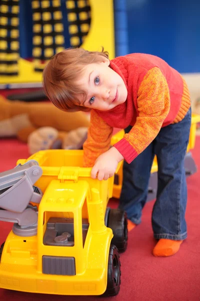 Niña juega con el coche de plástico en el jardín de infantes —  Fotos de Stock