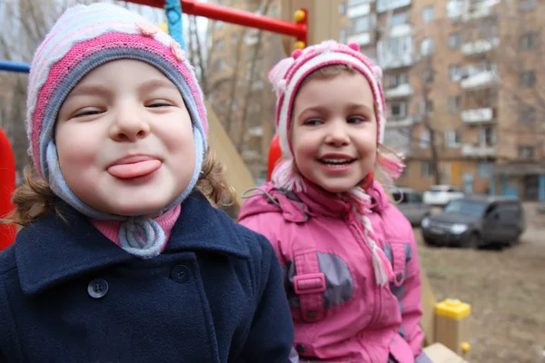 På lekplatsen flickan sätter ut tungan, andra skrattar — Stockfoto