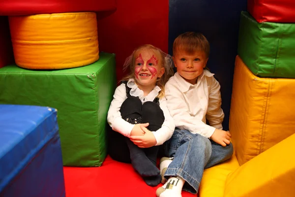 被绘的女孩和男孩坐在幼儿园 — 图库照片