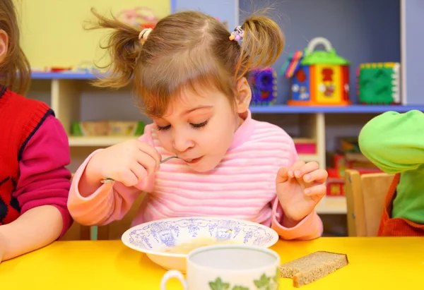 Menina come no jardim de infância — Fotografia de Stock