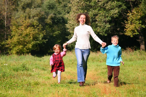 Mother with children run in wood, front view — Stock Photo, Image