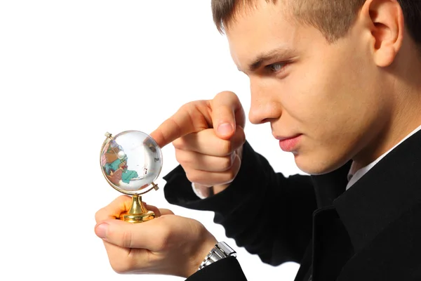 Young businessman touches finger glass globe in hand — Stock Photo, Image