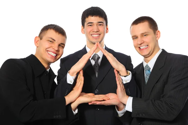 Троє молодих бізнесменів показують будинок з долонь — стокове фото