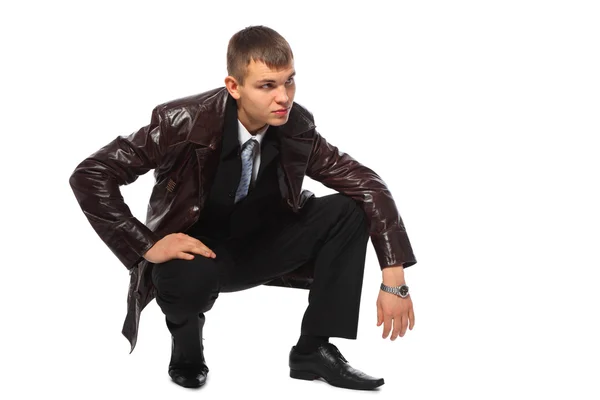Молодий бізнесмен у шкіряній куртці присідає — стокове фото