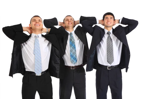 Drie zakenmensen handen achter hoofd te houden en naar boven kijken — Stockfoto