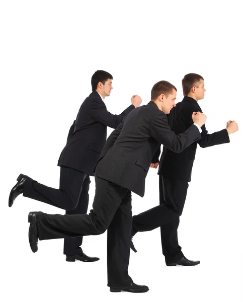 Três jovens empresários correm, vista lateral — Fotografia de Stock