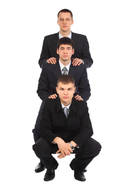 Три молодих бізнесмена один за одним — стокове фото