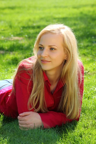 Красива блондинка лежить на траві — стокове фото