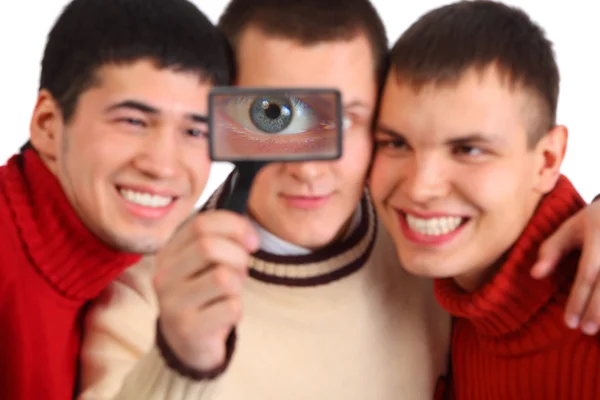 Tre amici guardano attraverso lente d'ingrandimento — Foto Stock