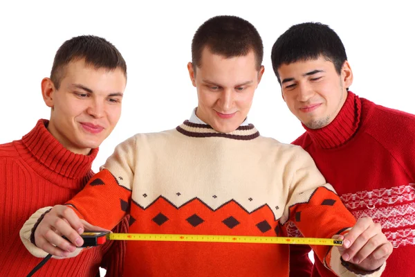 Three young men look on tape measure — Stock Photo, Image