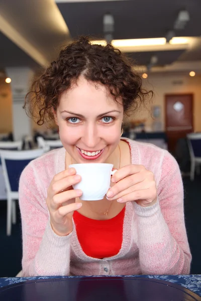 Wanita muda dengan cangkir di kafe — Stok Foto