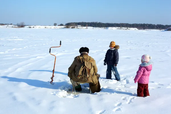 Dvě děti a rybář na zamrzlou řeku — Stock fotografie