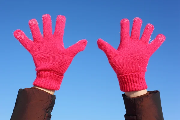 Zwei Hände in roten Handschuhen gegen blauen Himmel — Stockfoto