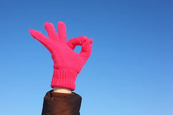 Handen in rode handschoen tegen blauwe hemel toont gebaar ok — Stockfoto