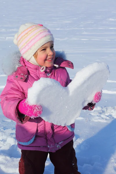 Little girl with snowy heart — Stock Photo, Image