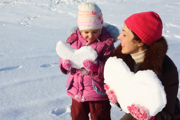 Liten flicka och mamma med snöiga hjärtan — Stockfoto