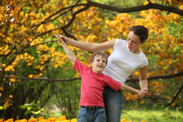 Mother with son to keep for hands in garden in spring — Stock Photo, Image