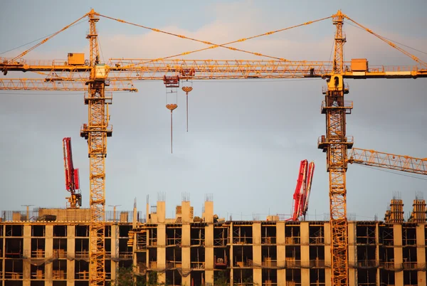 Twee kranen op het bouwen van gebouw — Stockfoto