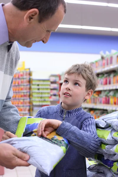 Ihtiyar bir adamın elinde paketiyle dükkanındaki çocukla — Stok fotoğraf