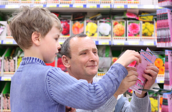 Elderly man with boy in shop of seeds
