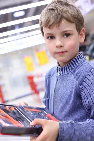 Chłopiec w sklepie z narzędziem w rękach — Zdjęcie stockowe