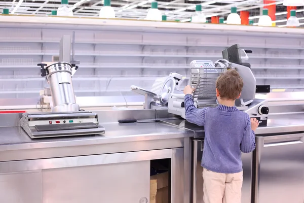 stock image Boy stands at scales in empty shop