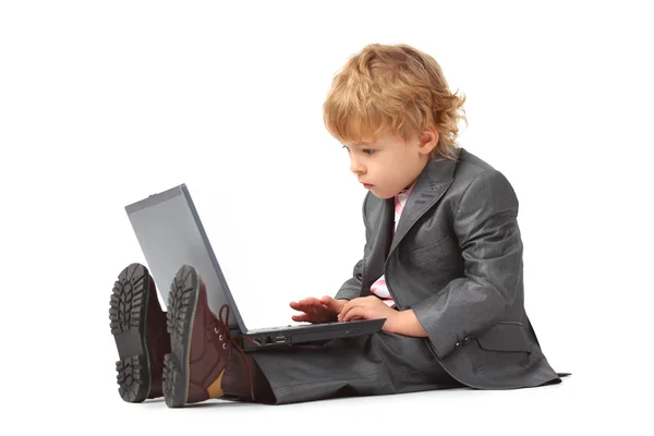 Pojke i kostym med bärbar dator — Stockfoto