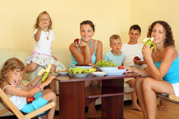 Gran familia feliz con niños come fruta en la habitación acogedora —  Fotos de Stock