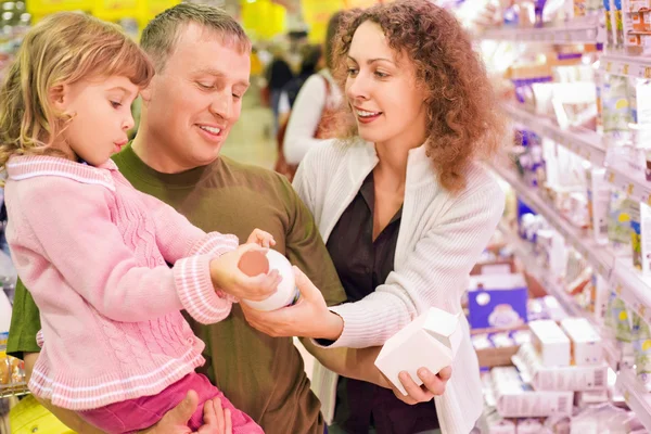 Kislány család vesz tejet a szupermarketben — Stock Fotó