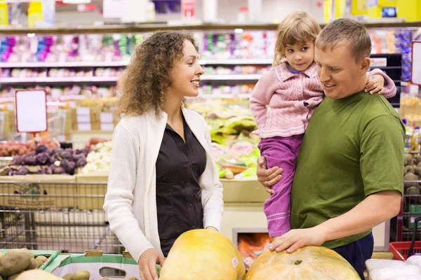 Familia con niña comprar calabaza en el supermercado —  Fotos de Stock