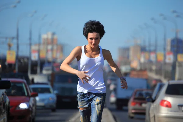 Menina corre na estrada do meio na cidade — Fotografia de Stock
