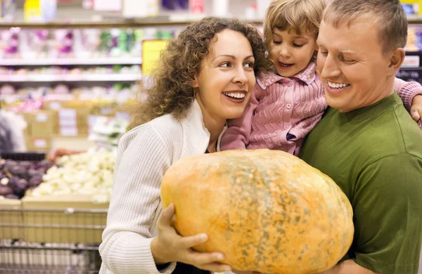 Семья с маленькой девочкой купить тыкву в супермаркете — стоковое фото