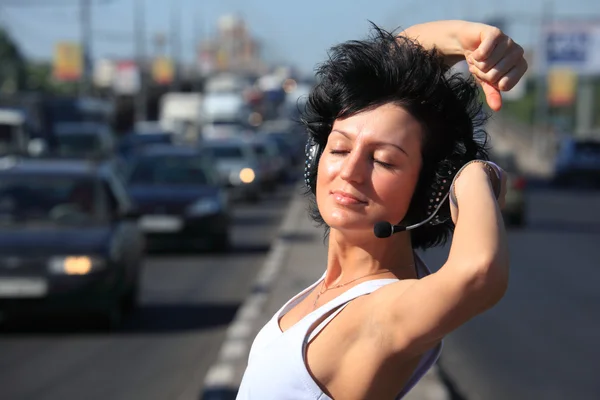 ヘッドフォンを高速道路の真ん中にセットの女の子 — ストック写真
