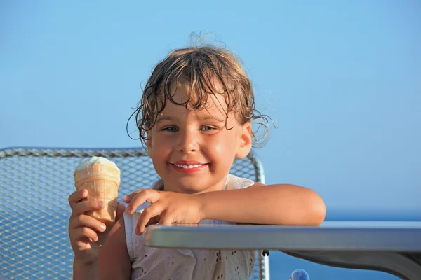 Smiling little girl eats ice-cream on resort — Stock Photo, Image