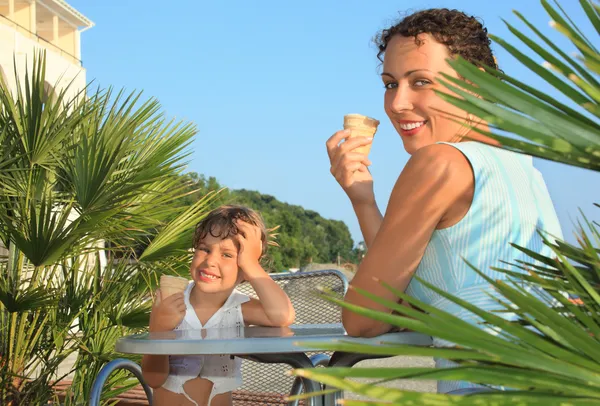 Bambina e giovane donna mangiano gelati vicino a palme su res — Foto Stock
