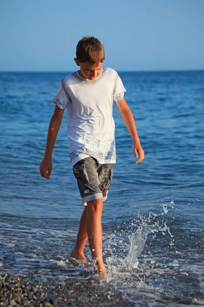 Tonåring pojke går på seacoast — Stockfoto
