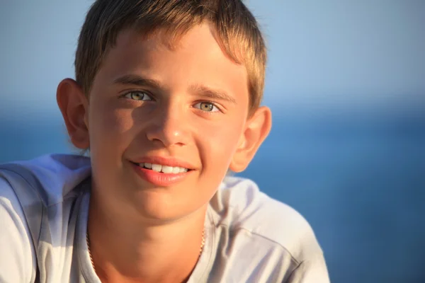 Sorrindo adolescente menino contra o mar — Fotografia de Stock