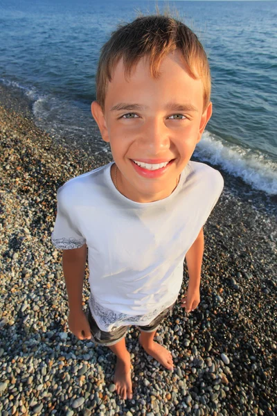Ler tonåring pojke stående på seacoast — Stockfoto