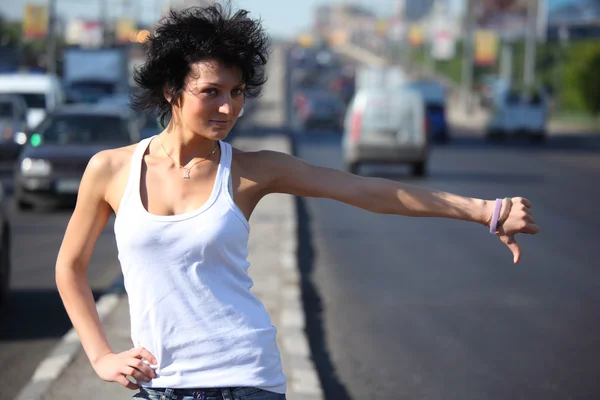 Junge Frau trampt auf Autobahn — Stockfoto