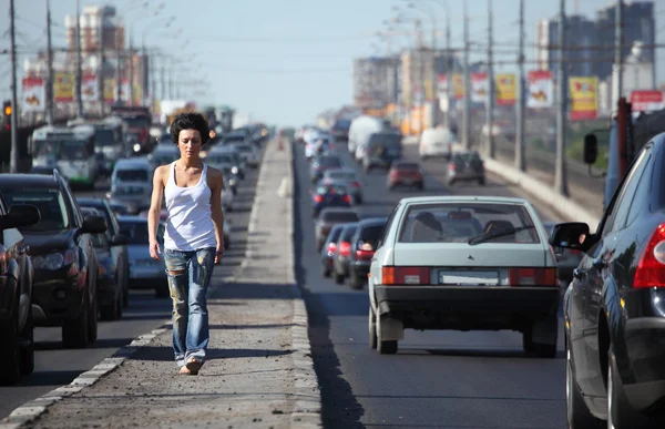 Lány megy autópálya közel a város — Stock Fotó