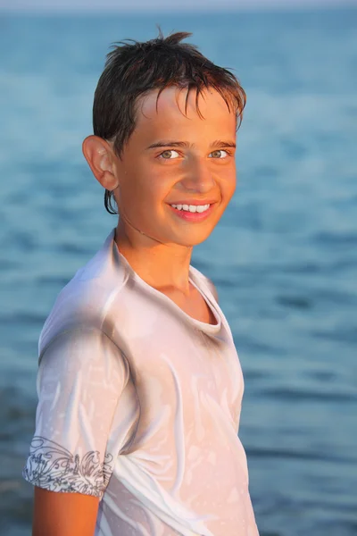 Adolescente menino em roupas molhadas no litoral — Fotografia de Stock