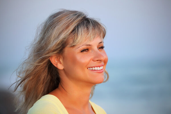 Beautiful young woman against sea, Looking afar