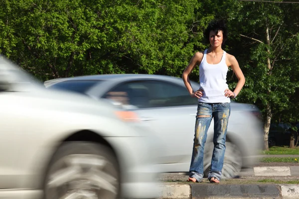 Meisje staat op weg onder auto 's — Stockfoto