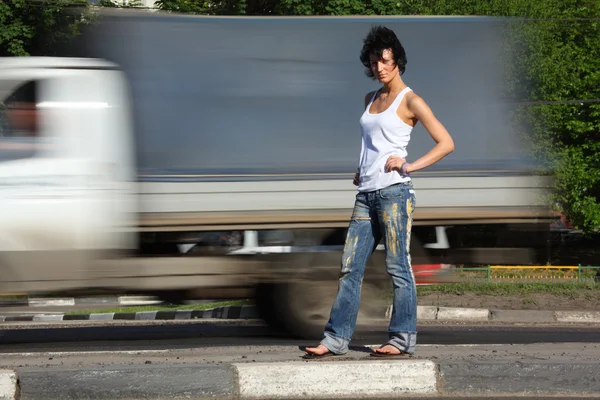 Девушка стоит на дороге среди автомобилей — стоковое фото