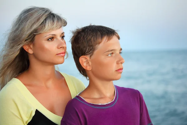 Junge und junge Frau am Abend am Strand und schauen in die Ferne — Stockfoto